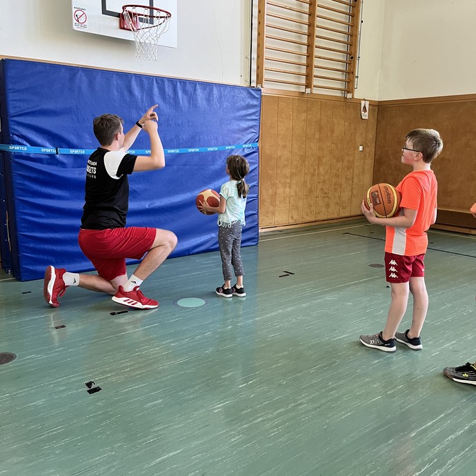 Schüler und Schülerinnen bei Basketball-Training (vergrößerte Bildansicht wird geöffnet)