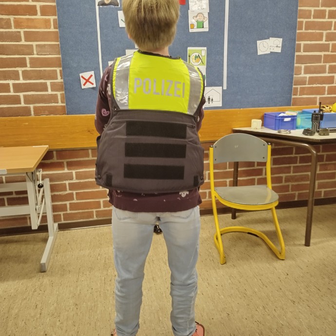 Schülerin mit Polizeiweste (vergrößerte Bildansicht wird geöffnet)