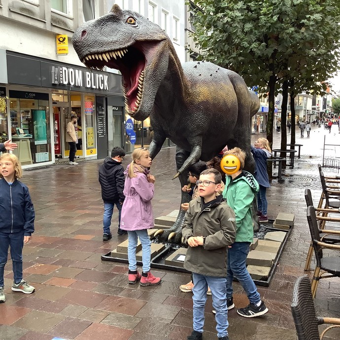 Schülerinnen und Schüler mit Dinosaurier (vergrößerte Bildansicht wird geöffnet)