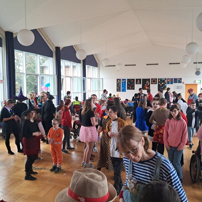 Schülerinnen und Schüler feiern in der Aula Karneval (vergrößerte Bildansicht wird geöffnet)
